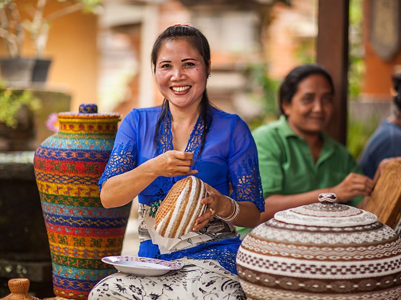Women artisans weaving and painting baskets and pots.