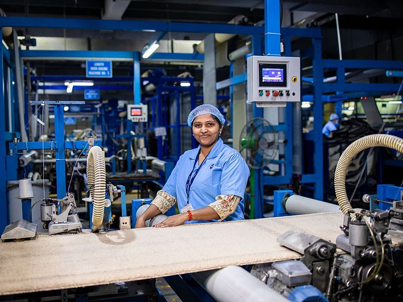 A woman at work on a machine line in a textile factory.